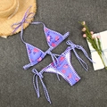 Flat lay of purple floral bikini set with checkered trim on a summery resort background - S / Purple