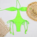 Vista plana de un monokini verde neón con aberturas, lazos con borlas y accesorios de playa - S / Verde Fluorescente