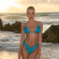 Detail of blue pleated bikini set showing high elastic fabric texture on a beach - S / Teal
