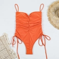 Détail d'un maillot de bain une pièce orange froncé avec lacets sur fond blanc - Orange