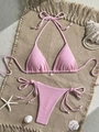 Pink textured bikini set with shell pendant and side tie bottoms on a sandy beach mat - S / Pink