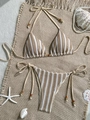 Detail of knit striped bikini with beads, shells and starfish on beige woven mat - Brown