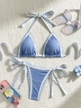 Set bikini azzurro testurizzato con bordi bianchi e fermaglio a fiore su tappeto - S / Blu