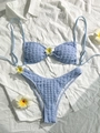 Detalle del bikini de tela seersucker azul claro con textura gofrada y flor de frangipani - S / Azul