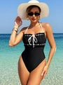 Elegant black and white contrast one-piece swimsuit with bow detailing on a sunny beach - S / Black and White