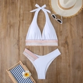 Flat lay of white halter bikini set with colorful wavy elastic bands on wooden background - S / White
