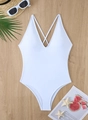 Flat lay of a white deep V-neck one-piece swimsuit with cross back straps on wood surface - S / White