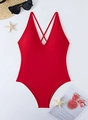 Detail of red one-piece swimsuit with plunging V-neck and criss-cross straps on white surface - S / Red