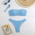 Flat lay of light blue smocked texture bandeau bikini set with summer beach accessories - S / Blue