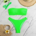 Flat lay of neon green textured bandeau bikini with sunglasses and vacation accessories - S / Green