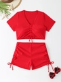 Flat lay of red two-piece swimsuit with short sleeves, ruched details, and beach accessories - S / Red