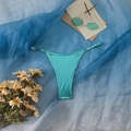 Dettaglio slip bikini verde acqua metallizzato con fibbie regolabili e finitura lucida - S / Smeraldo
