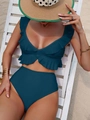 Detail eines dunkelgrünen High-Waist-Bikinis mit Rüschen-V-Ausschnitt auf einer Liege - Malachitgrün