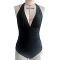 Detail of black one-piece swimsuit with halter deep V-neck and ruched waist on a mannequin - Black