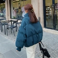 Outdoor shot of a loose duck-blue hooded winter puffer jacket with ribbed cuffs - S / Blue