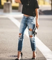 Dettaglio di jeans skinny blu con strappi sulle ginocchia e lavaggio con effetto baffi - S / Blu Lago