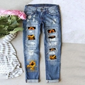 Dettaglio dei jeans blu con toppe di streghe di Halloween e strappi sul tessuto denim - S / Stile Di Stampa Scopa Della Strega