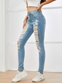 Dettaglio dei jeans skinny azzurri a vita alta con strappi sulle ginocchia e orli a vivo - XS / Azzurro