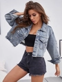 Detail of short denim jacket featuring distressed ripped elements and a frayed hemline - Blue