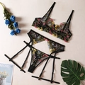Flat lay of floral embroidered sheer lingerie set with bra, garter belt and thong - Black