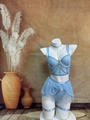 Détail d'un ensemble babydoll bleu clair avec tulle et chaînes dorées décoratives sur un mannequin - Bleu clair