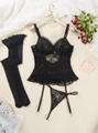 Elegante completo intimo in pizzo nero con reggicalze e calze su sfondo di peluche - S / Nero