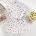 Flat-Lay-Ansicht eines Kirschprint-Pyjama-Sets aus Rippstrick mit Shorts und Deko - S / Weiß mit Kirschen