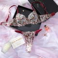 Dettaglio flat lay di completo intimo in pizzo floreale rosso con reggiseno push-up e perizoma - S / Borgogna Bianco