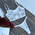 Detail van witte kanten lingerieset met baleinen en string op een donkere houten achtergrond - S / Wit