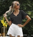 Detail van de top met stippenprint en ruchesmouwen en witte denim short met rafels - S / Zwart