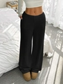 Dettaglio dei pantaloni neri in maglia a gamba larga con trama a coste e vita elasticizzata - S / Nero