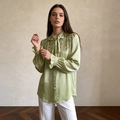 Detail van lichtgroene satijnen blouse met lovertjes, rucheskraag en elegante strik - M / Groen