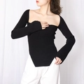 Dettaglio degli spacchi laterali e dell'orlo asimmetrico del top in maglia nera a coste - S / Nero