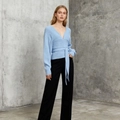 Detail of light blue knit top featuring cross V-neckline and tie waist ribbon design - One Size / Blue