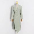 Dettaglio del cappotto verde chiaro con tagli laterali in vita e orlo asimmetrico - S / Verde