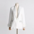 Detailed view of the diamond neckline and ostrich feather cuffs on a white luxury blazer - White