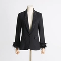 Detailed view of rhinestone lapels and ostrich feather cuffs on a black blazer - Black