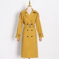 Detail view of mustard trench coat featuring double-breasted buttons and adjustable waist belt - XS / Yellow