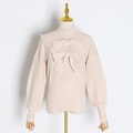 Détail d'un pull en maille rose avec nœuds décoratifs et texture côtelée - L / Abricot
