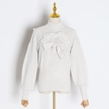 Détail du pull en tricot blanc orné de grands nœuds décoratifs et d'un col montant côtelé - S / Blanc