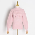 Détail du pull en maille rose avec nœuds 3D élégants et col montant sophistiqué - S / Rose