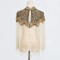 Detailed close-up of golden sequins and long beaded fringe on a luxury shawl - Gold