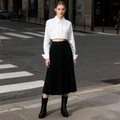 Detalle de camisa corta blanca con textura de rejilla y falda plisada negra en la calle - S / Blanco