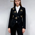 Détail d'un blazer noir cintré avec broderie d'abeille dorée et fermoir papillon argenté - S / Noir