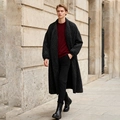Outdoor street style shot of a long black quilted coat with classic diamond patterns - One Size / Black