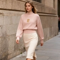 Détail du pull en maille rose clair avec col montant et ornement métallique doré en serrure - S / Abricot