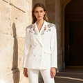 Gedetailleerde weergave van zilveren lovertjes en kralen op de revers van een witte blazer - M / Wit