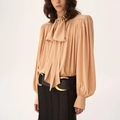 Detail of elegant apricot long sleeve shirt featuring bow-tie neck and pleated lantern sleeves - One Size / Apricot Pink