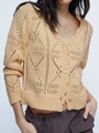 Gros plan d'un gilet en maille beige avec motifs ajourés en losange et boutons assortis - S / Abricot