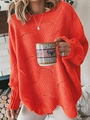 Close-up of orange knit sweater showing intricate wavy hollow out texture and ribbed cuffs - Watermelon red